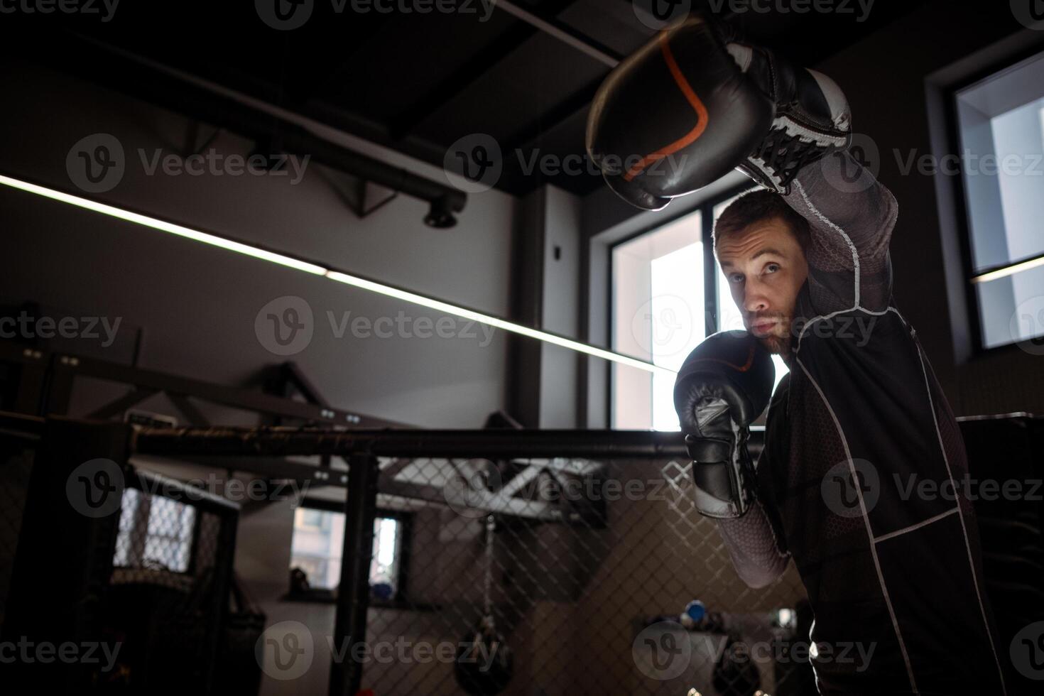 Boxer throwing powerful left hook during shadowboxing in gym photo