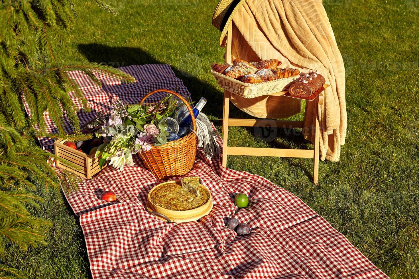 Summer picnic setup with quiche and pastries on grass photo