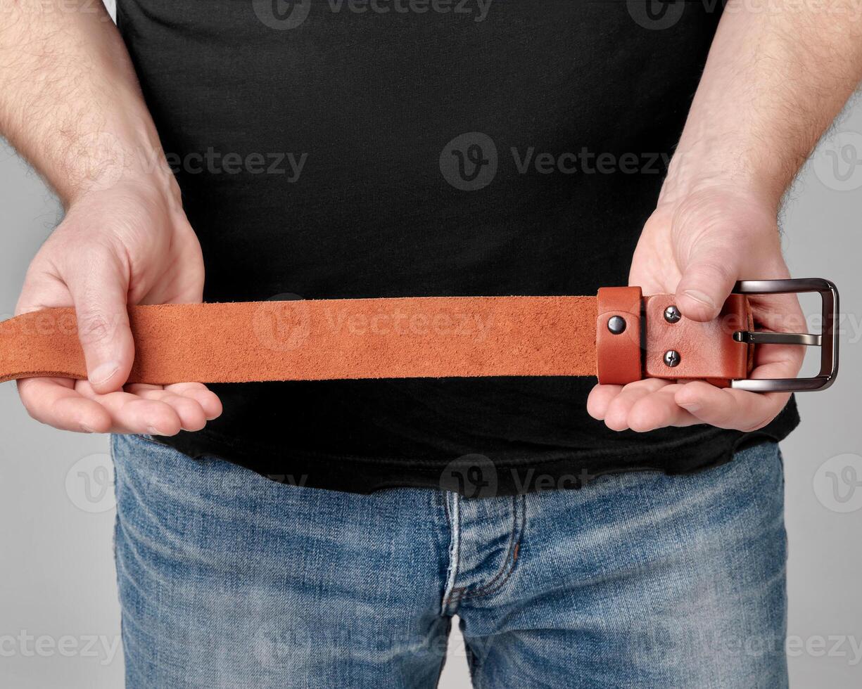 Terracotta leather belt with humorous personalized inscription in male hands photo