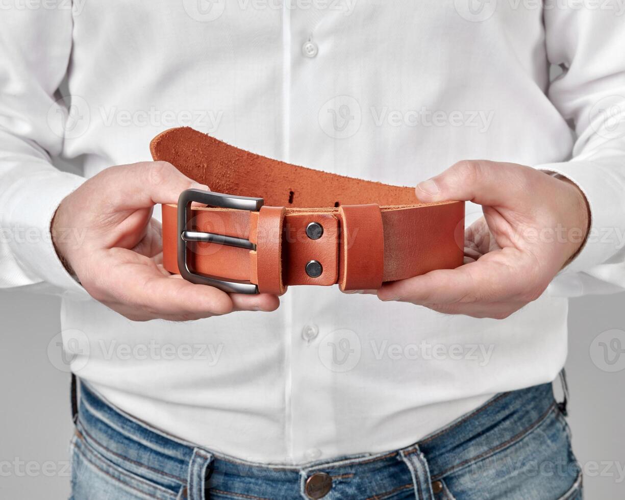 Terracotta leather belt with custom DAD embossing in male hands photo