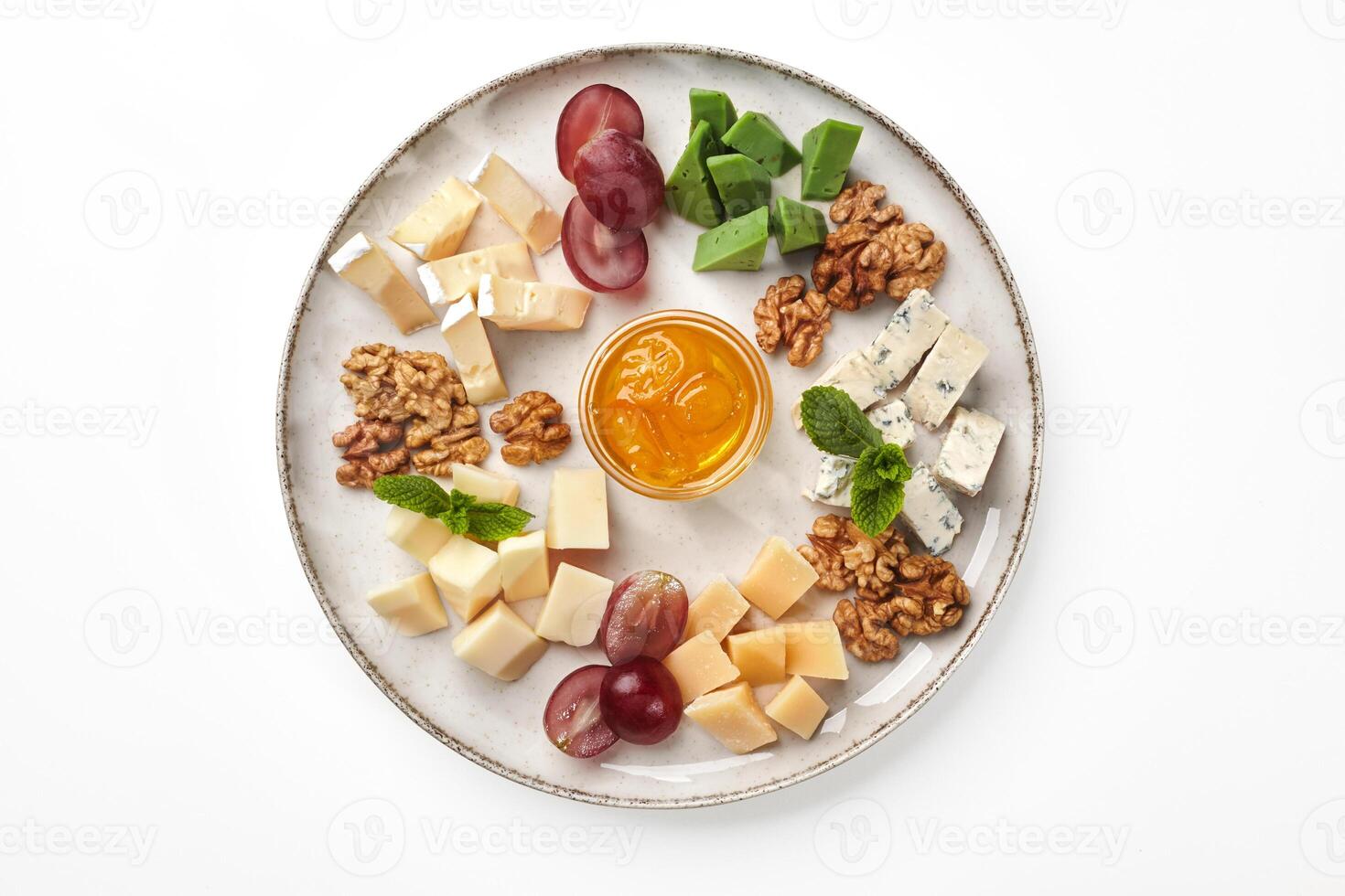 Cheese platter with honey, grape and walnuts on plate photo
