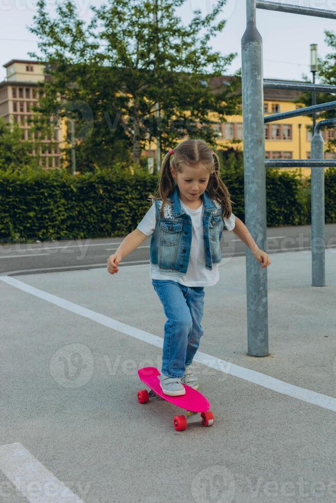 Cute little girl riding on a skateboard.girl 5 years old photo