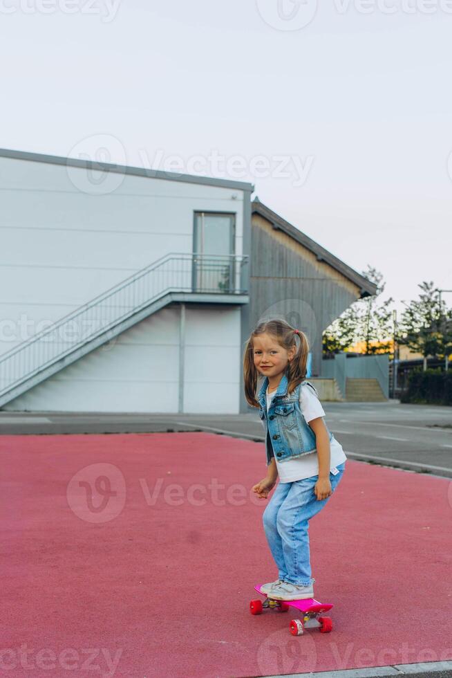 Cute little girl riding on a skateboard.girl 5 years old photo
