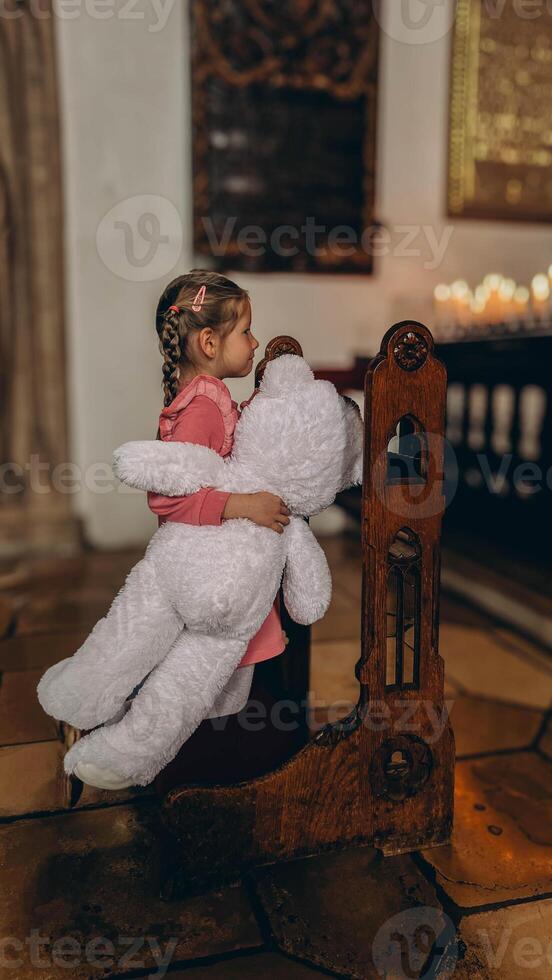 Little girl playing with his toy in catholic church. photo