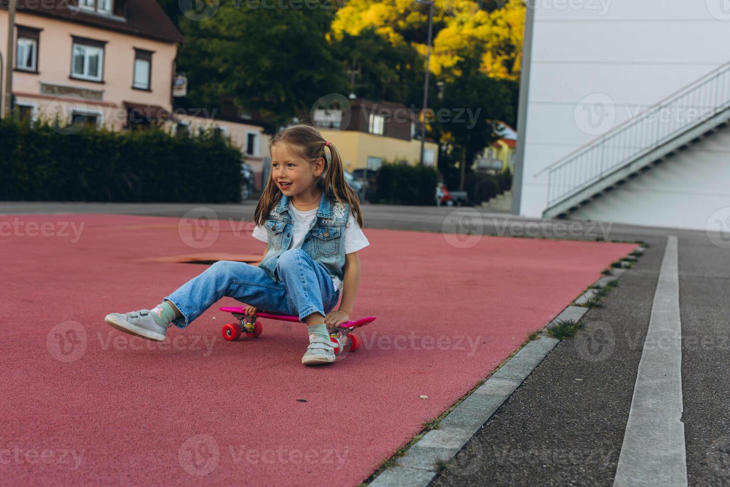 Cute little girl stands with a skateboard photo