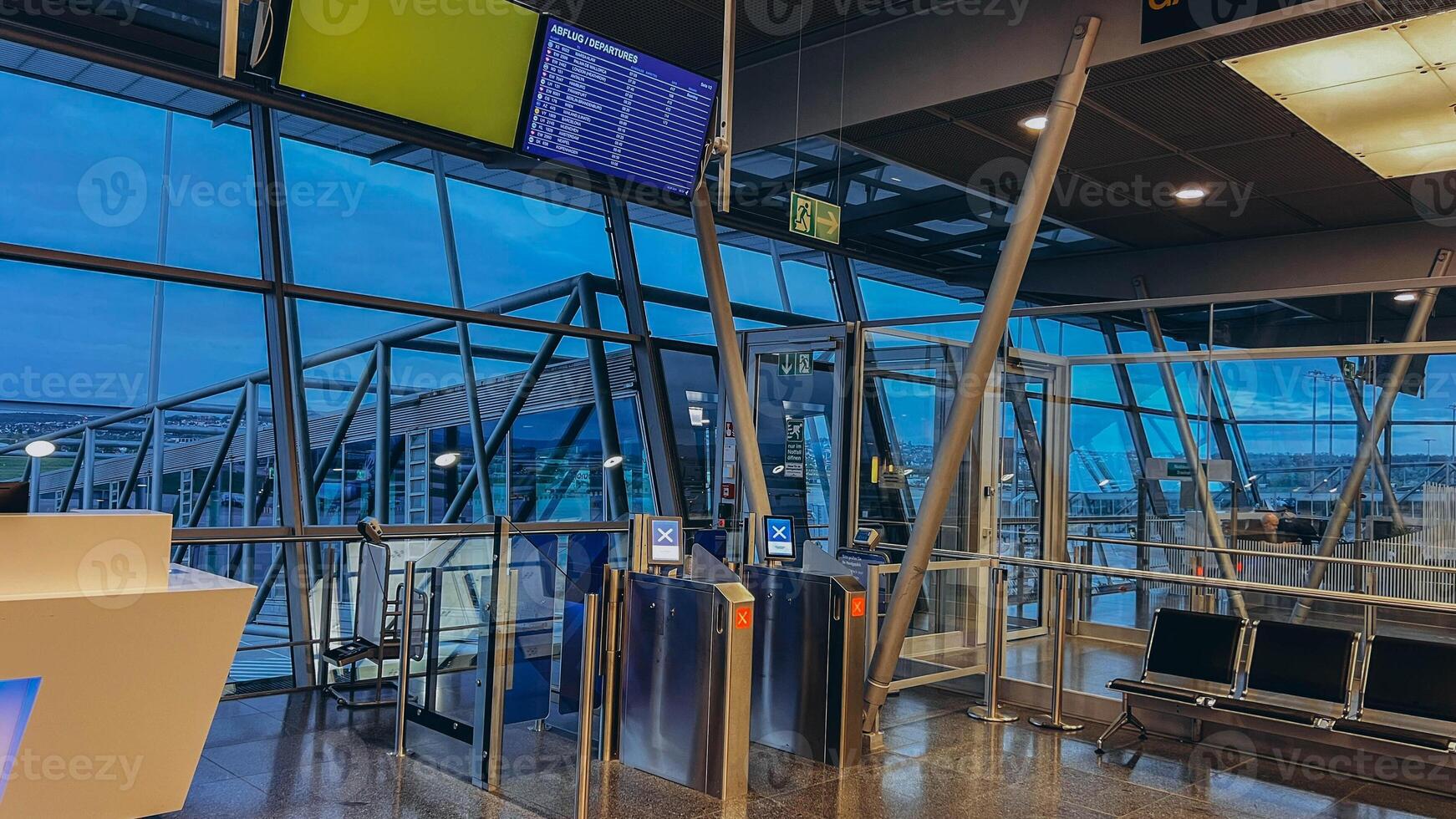 An empty terminal, aircrafts are waiting and preparing for their next flight and one of them taken off photo