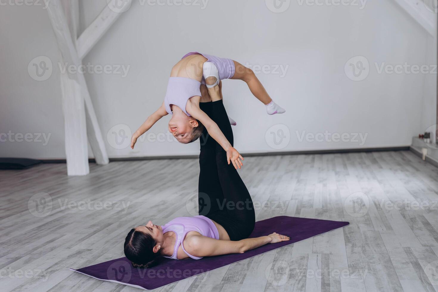 mother and daughter do sports and gymnastics on a white background, two girls do fitness photo