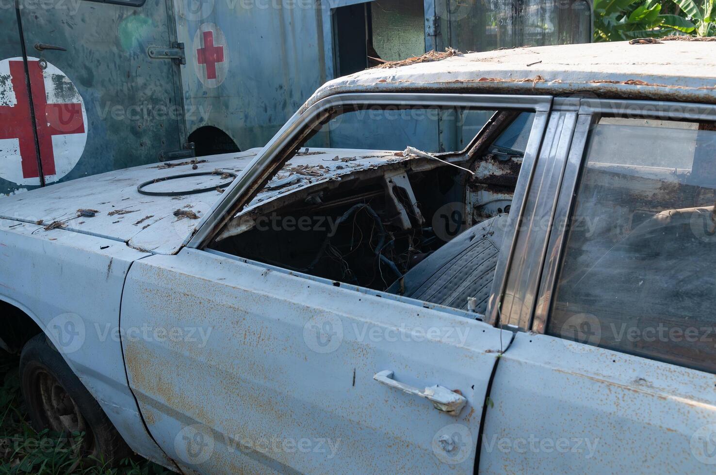 an old abandoned and damaged car parked in the backyard photo