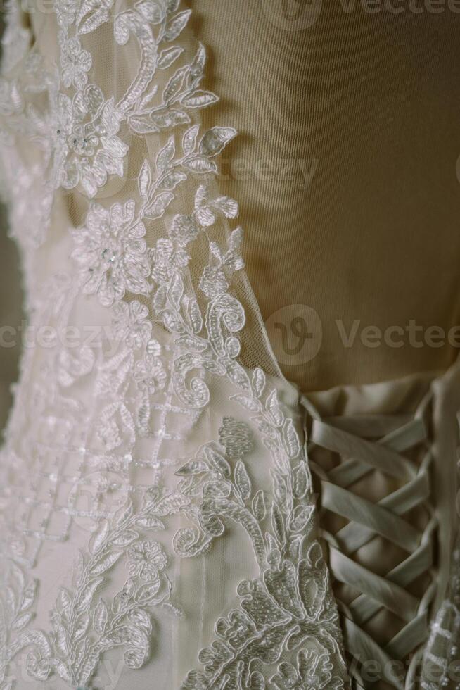 Close-up of a beautiful white gown, showcasing intricate details and delicate craftsmanship. photo