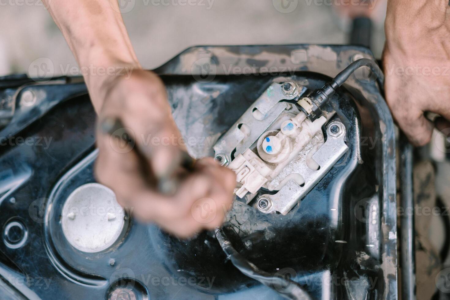 A motorcycle mechanic inspecting a damaged engine photo