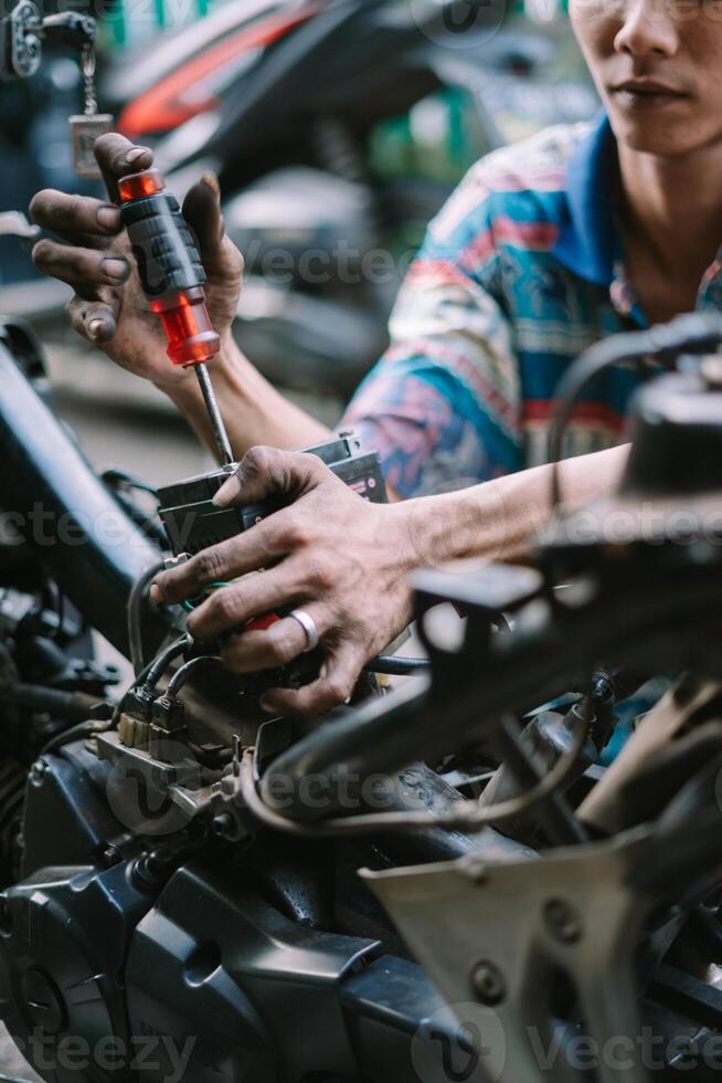 A motorcycle mechanic inspecting a damaged engine photo