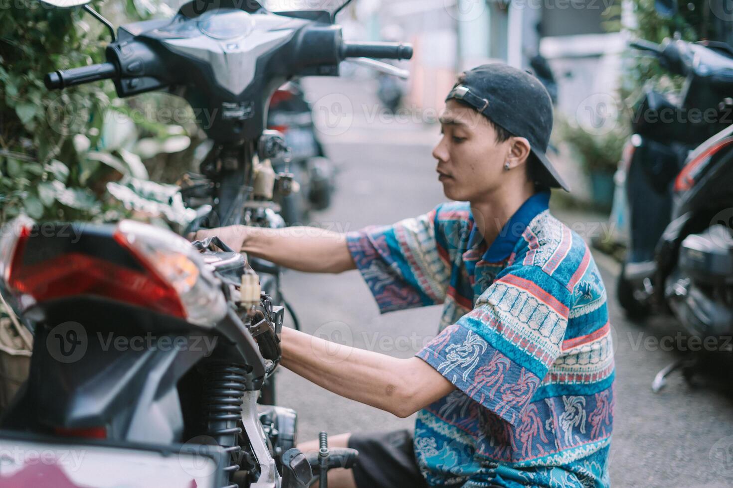 A motorcycle mechanic is checking a damaged engine photo