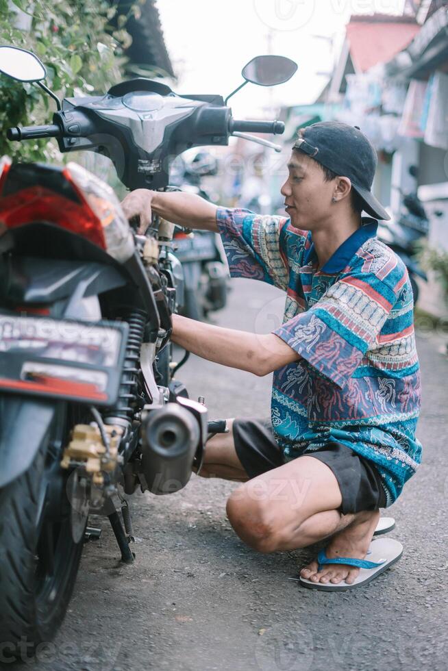 A motorcycle mechanic is checking a damaged engine photo