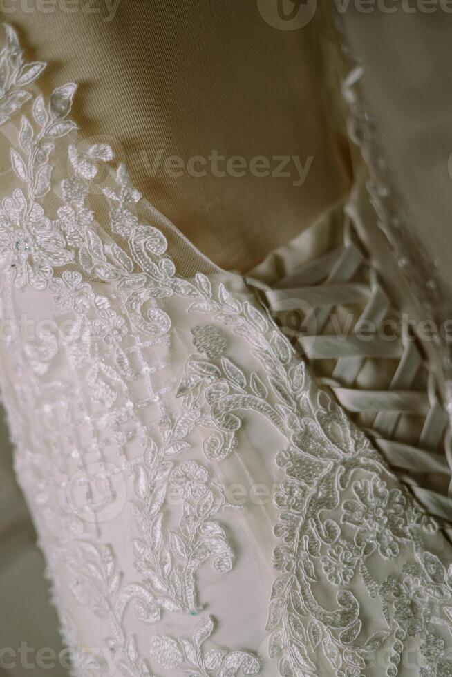 Close-up of a beautiful white gown, showcasing intricate details and delicate craftsmanship. photo