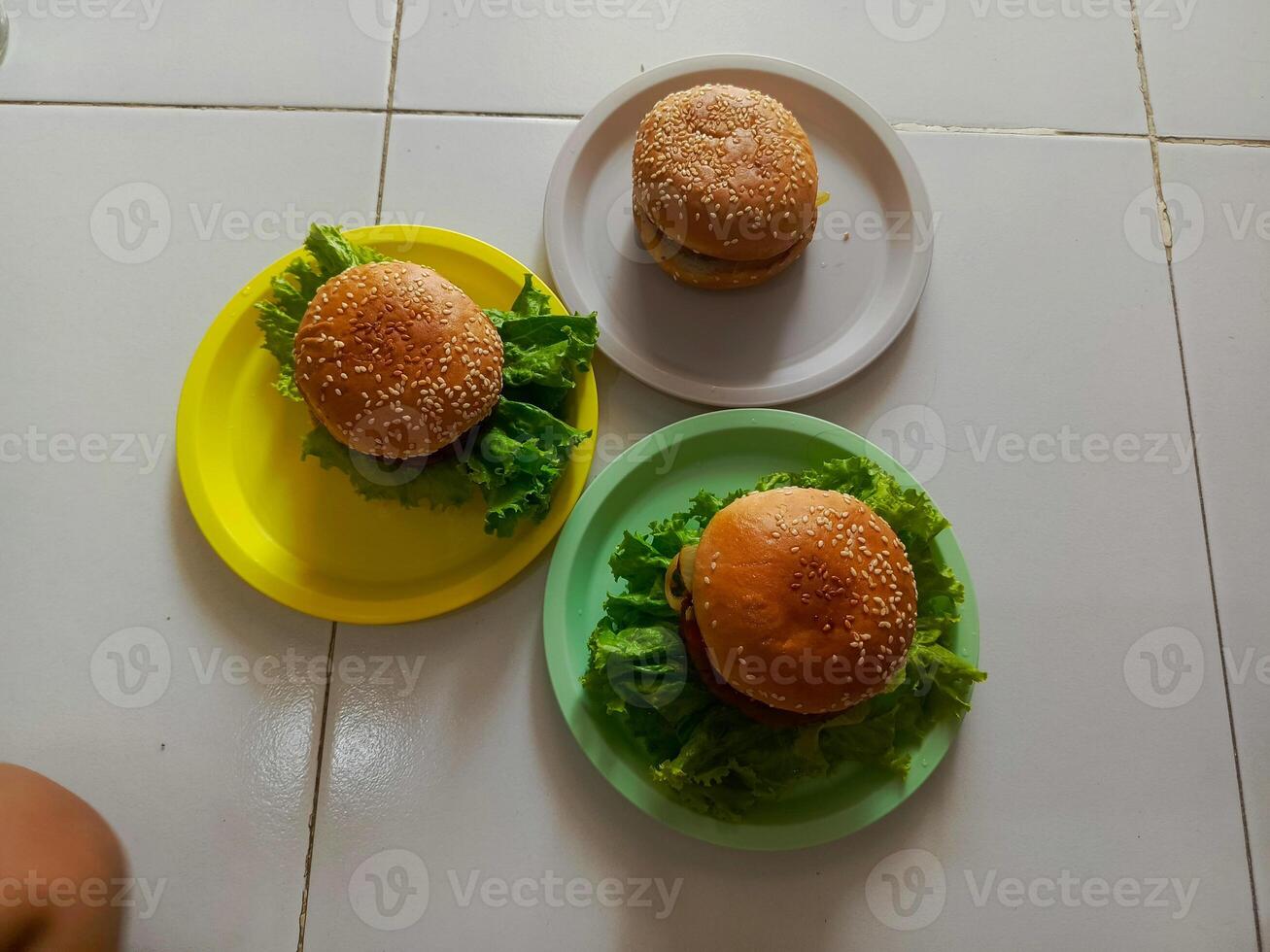 Three delicious burgers served on a plastic plate, ready to be enjoyed. photo