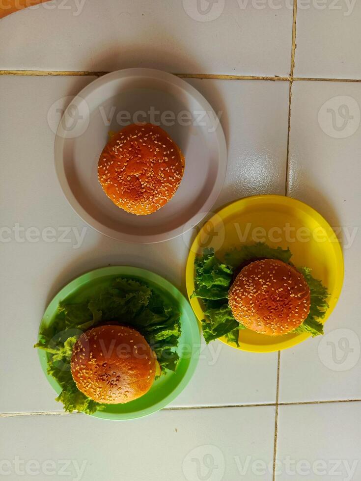 Three delicious burgers served on a plastic plate, ready to be enjoyed. photo