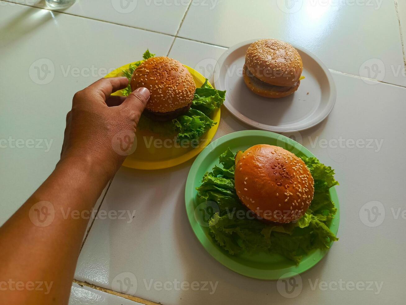 Three delicious burgers served on a plastic plate, ready to be enjoyed. photo