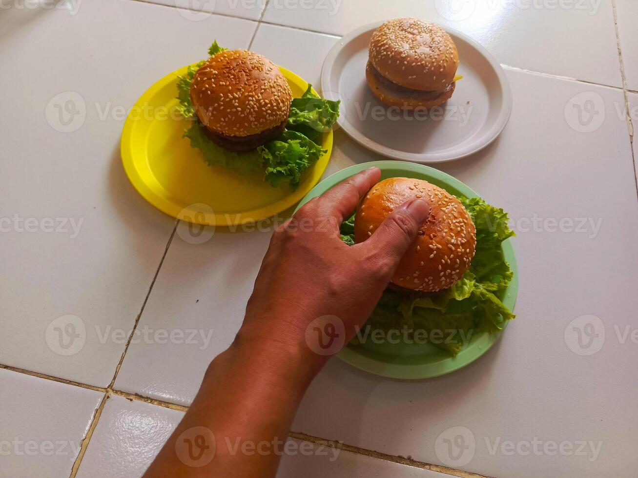 Three delicious burgers served on a plastic plate, ready to be enjoyed. photo