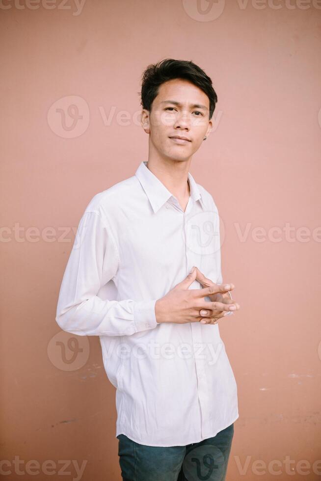 A man folding his fingers with a sharp gaze, exuding concentration or perhaps showcasing a gesture of determination and focus. photo