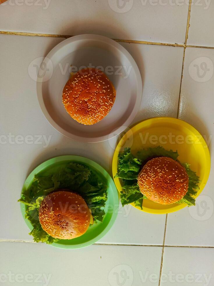 Three delicious burgers served on a plastic plate, ready to be enjoyed. photo