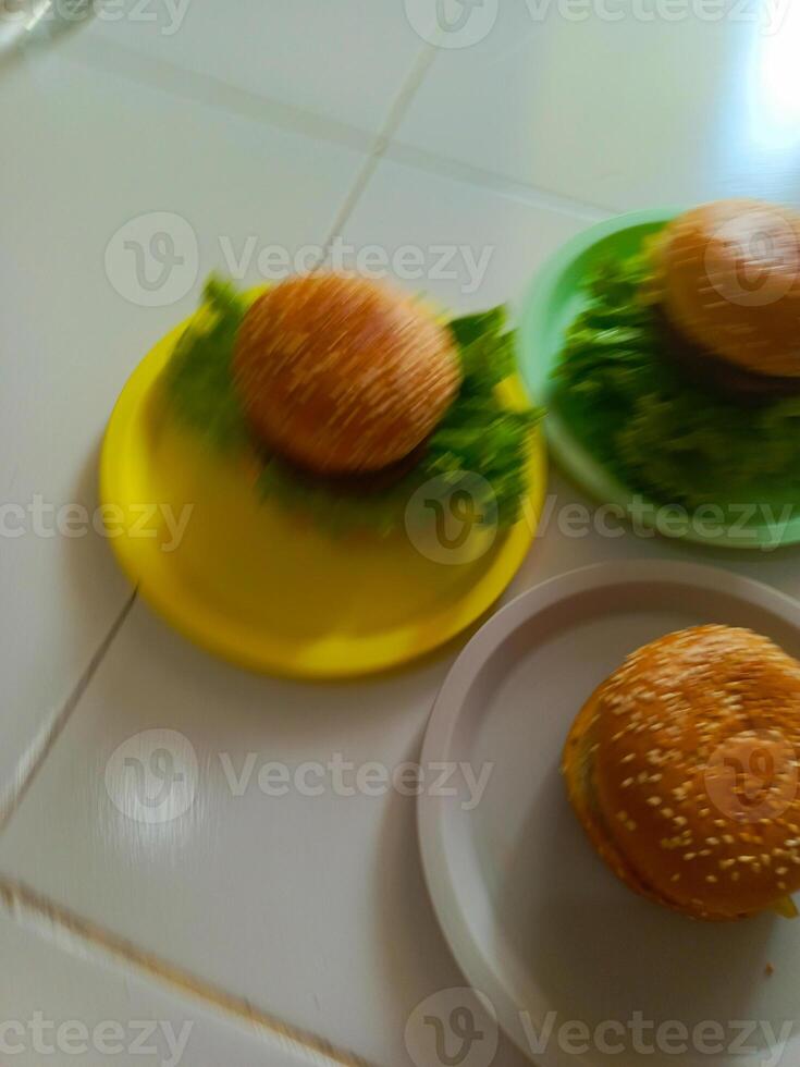 Three delicious burgers served on a plastic plate, ready to be enjoyed. photo