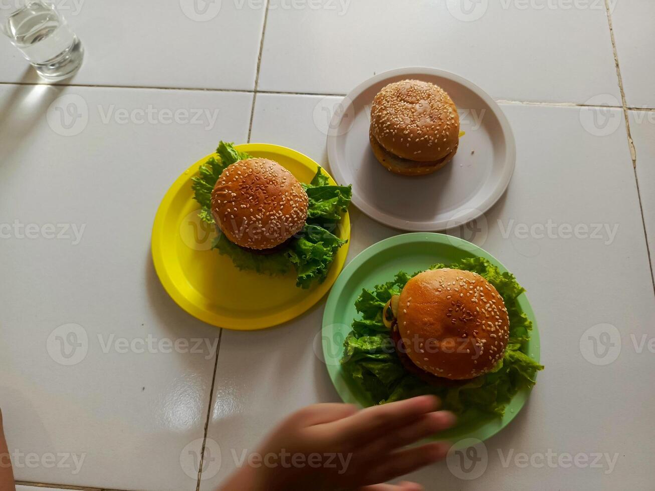 Three delicious burgers served on a plastic plate, ready to be enjoyed. photo