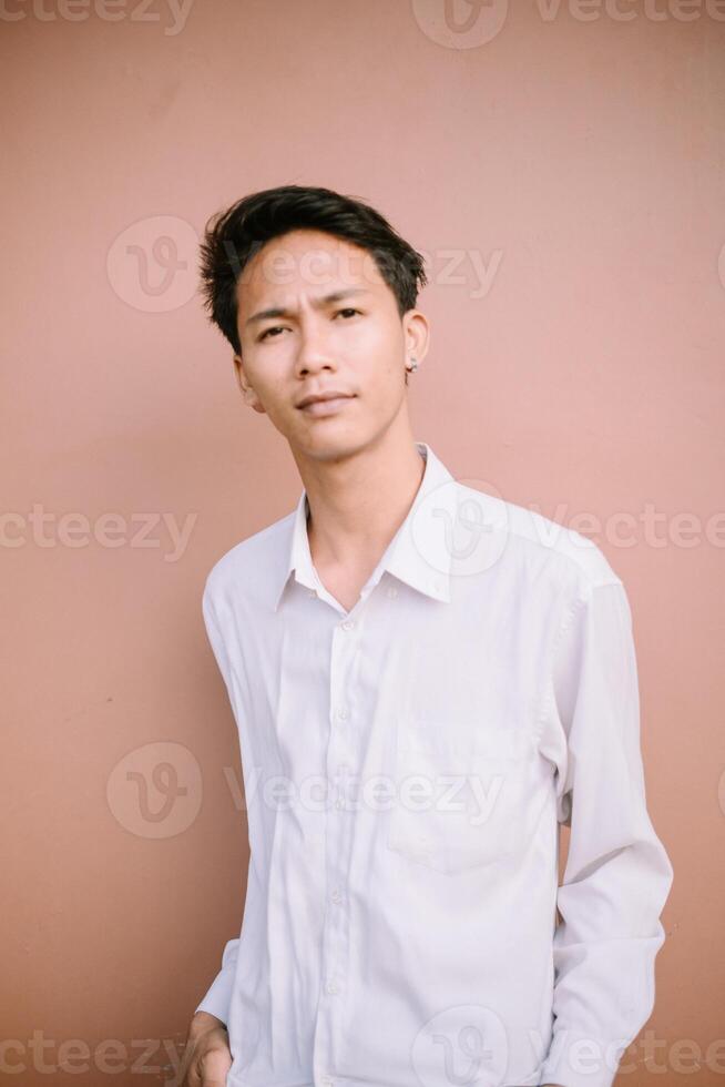 A man with a neutral expression facing forward, embodying a sense of calm and introspection in a simple yet captivating image. photo