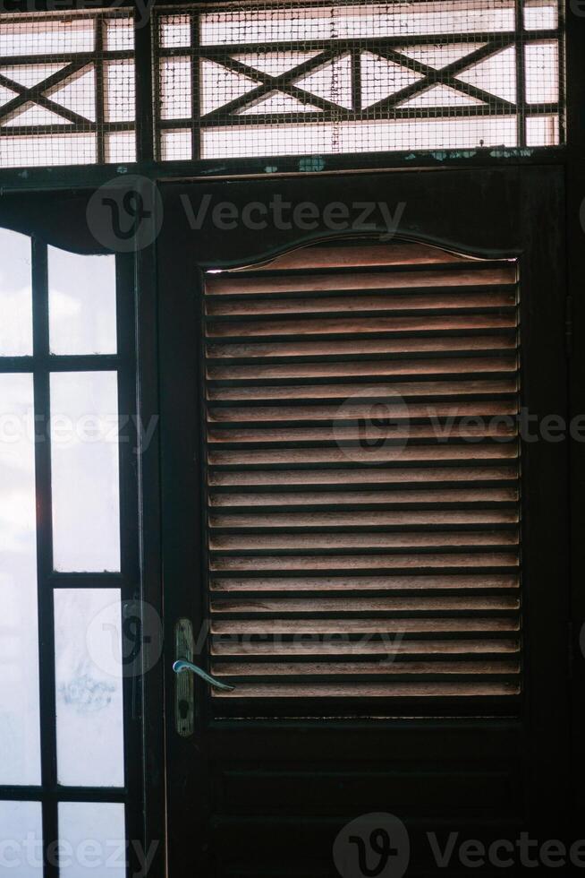 A wooden door featuring linear vents, blending functionality and rustic charm, perfect for enhancing ventilation and aesthetic appeal in any space. photo
