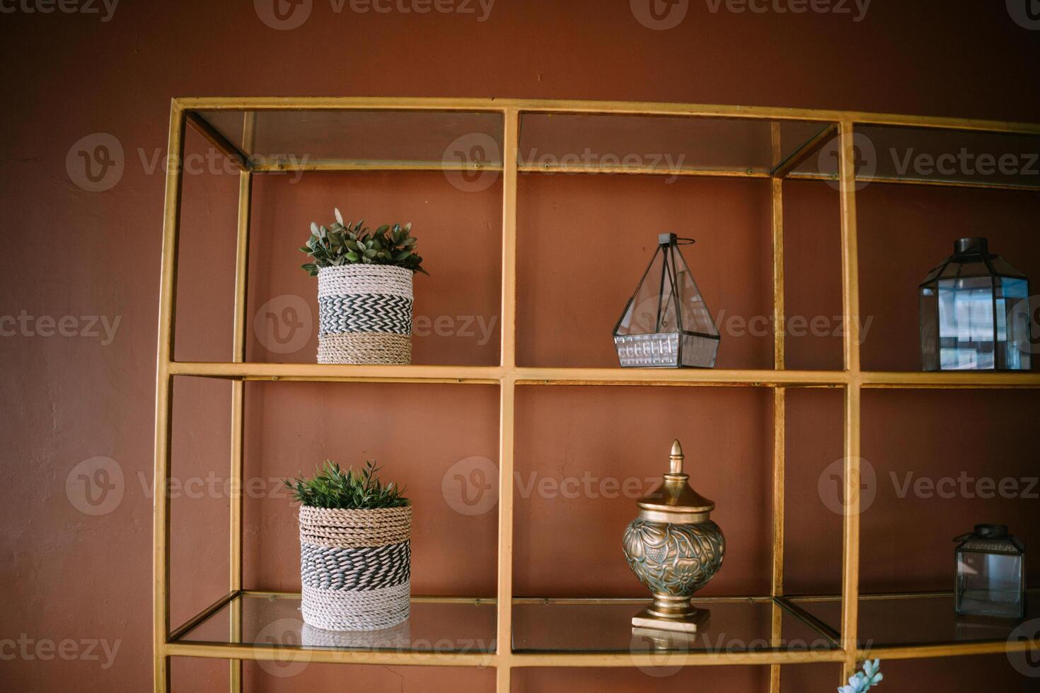 An arrangement of artificial plants and assorted decorations displayed on a metal shelf, adding a touch of greenery and charm to interior decor photo