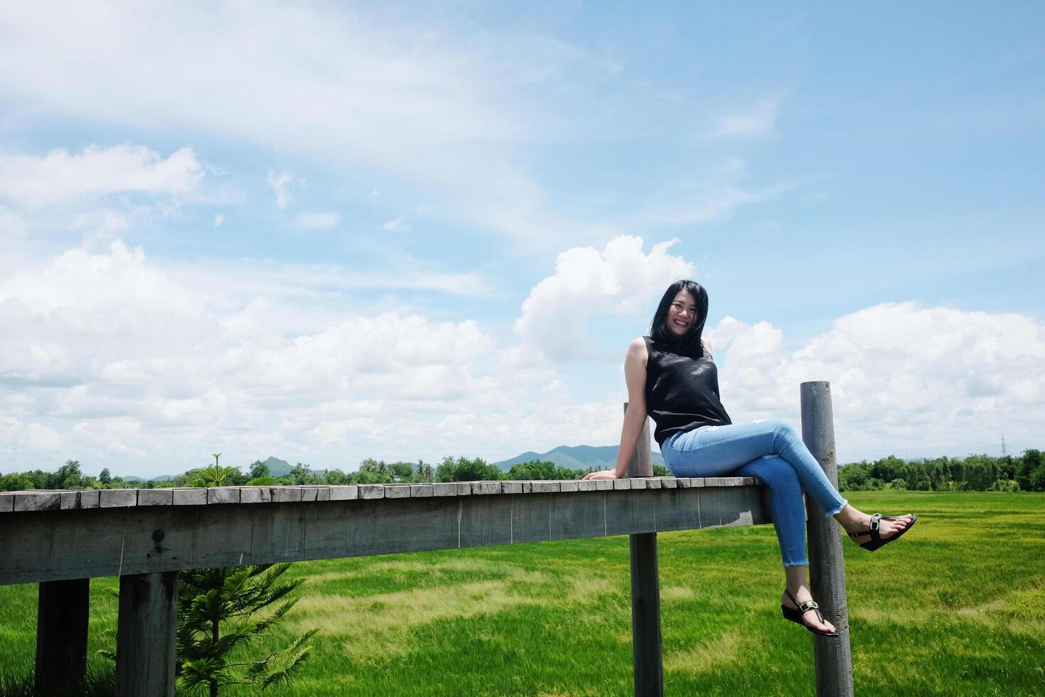 Asian woman sitting on Wooden bridge is freedom and happy on the blue sky. Happiness of life is successful and travel in the world. photo