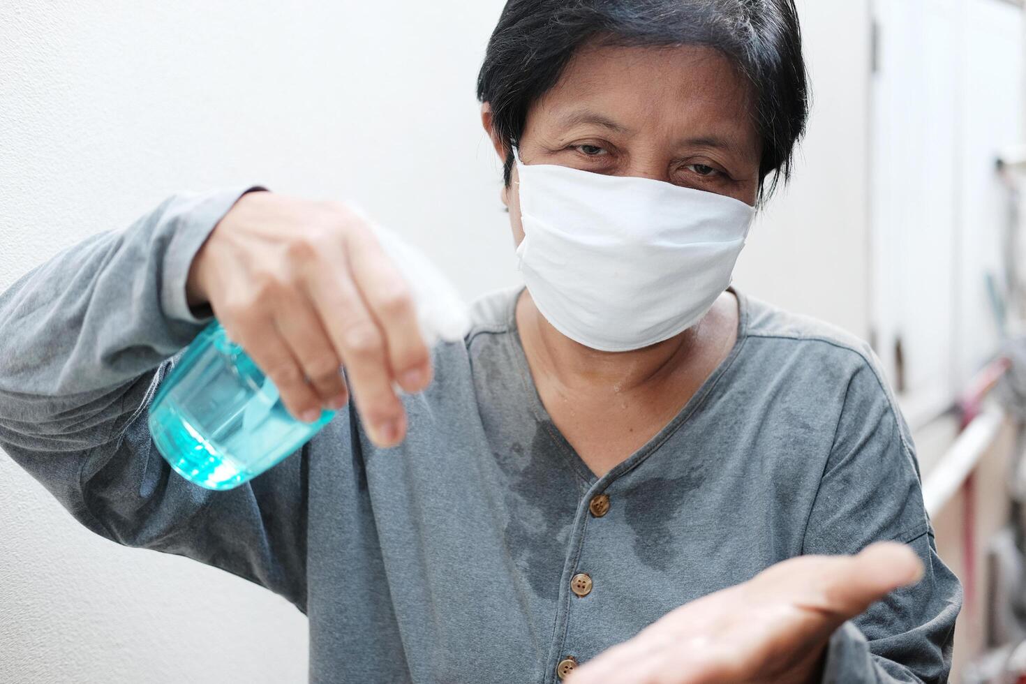 Asian Housekeeper wearing white mask with Alcohol. Health and illness Concept photo
