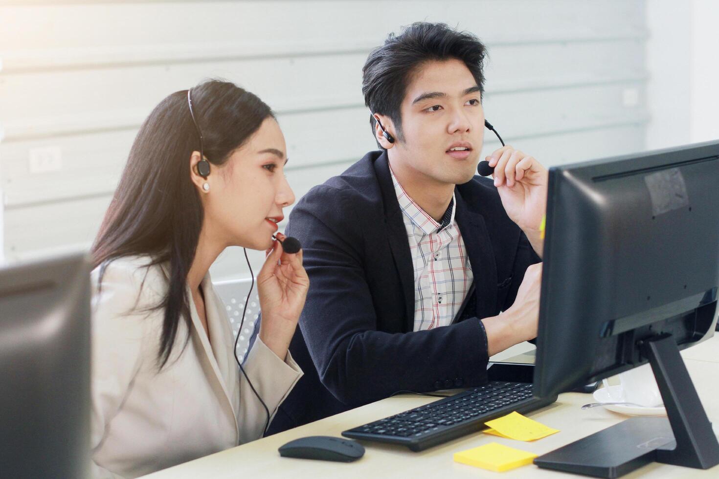 Business Call Center and technical Support staff or receptionist phone operator Discussing and working for teamwork with computer. Asian customer support team. photo
