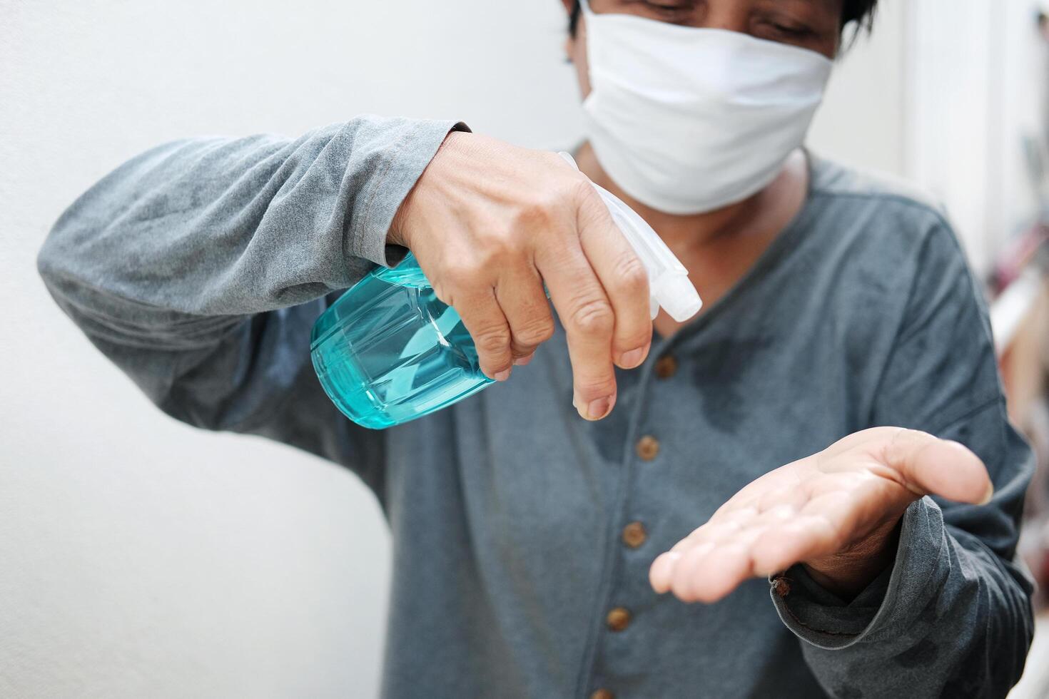 Asian Housekeeper wearing white mask with Alcohol. Health and illness Concept photo