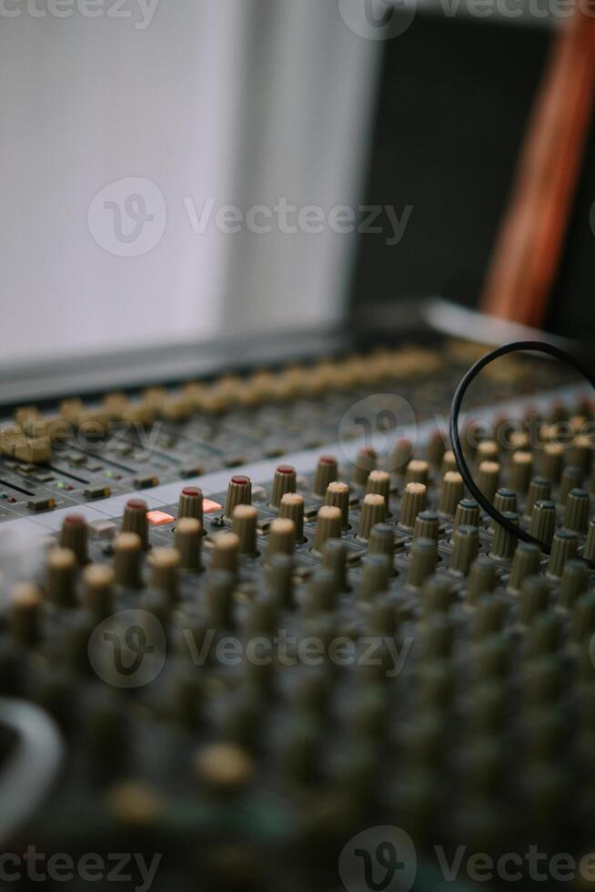 An audio mixer with its knobs and sliders meticulously adjusted, embodying precision and control in the art of sound engineering and music production photo