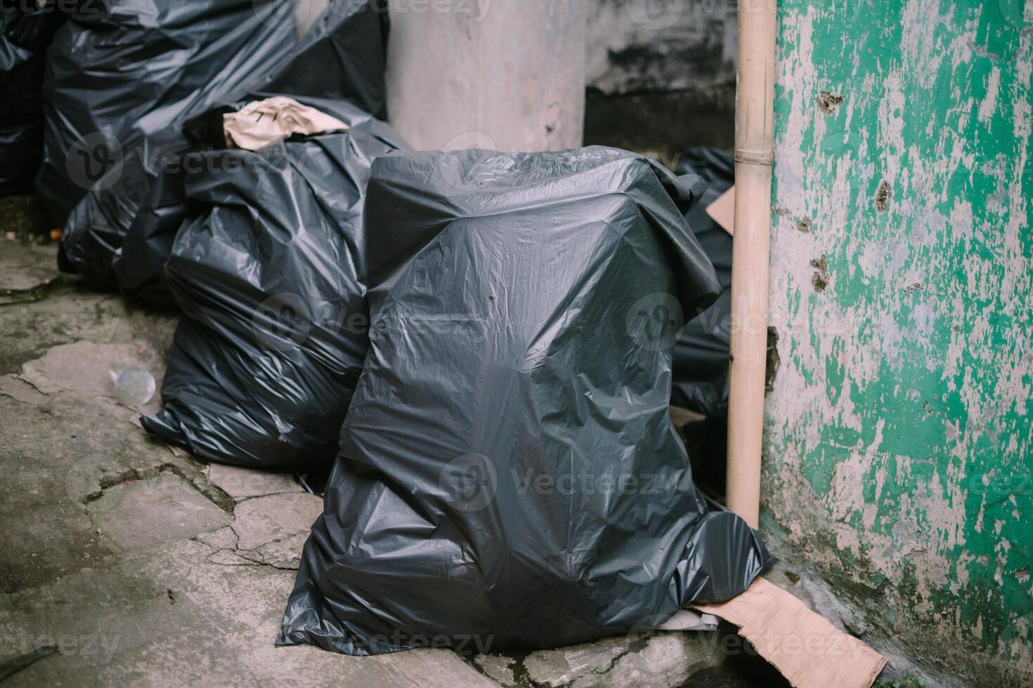 Collected trash bags ready for disposal at the landfill photo