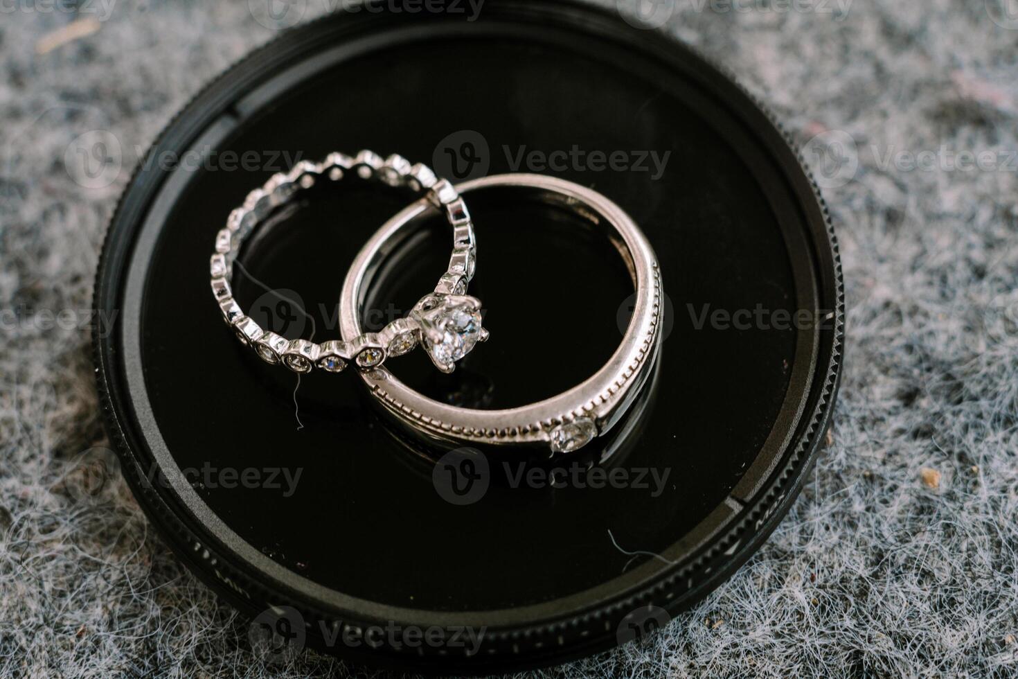 A stunning wedding ring resting on a sleek black circular glass surface, reflecting elegance and everlasting commitment in a contemporary setting photo