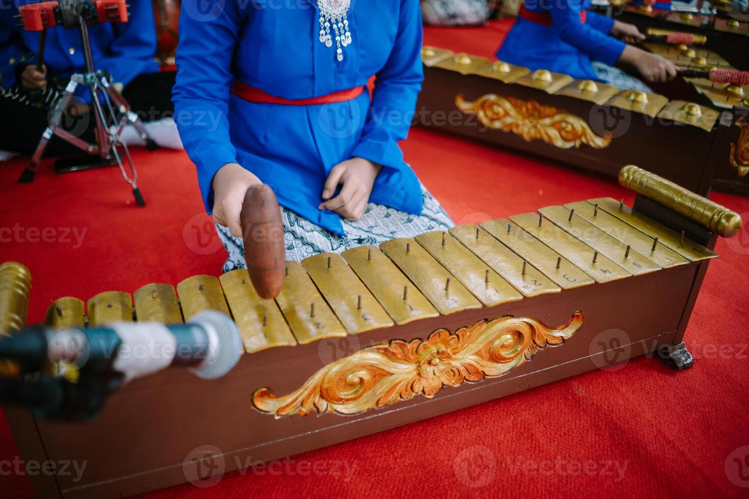 A captivating image of a young girl playing the enchanting tones of a traditional gamelan orchestra, a cultural gem from Indonesia photo