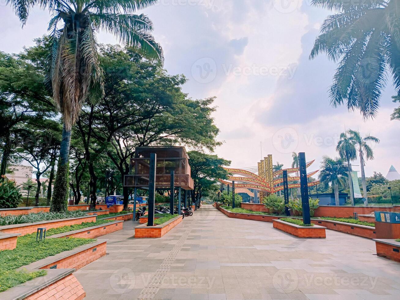 A picturesque pedestrian zone in TMII, inviting strollers to explore Indonesia's diverse culture amidst lush greenery and vibrant architecture. photo
