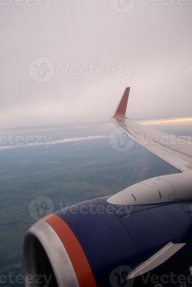 Airplane flight. Wing of an airplane flying above the clouds. photo