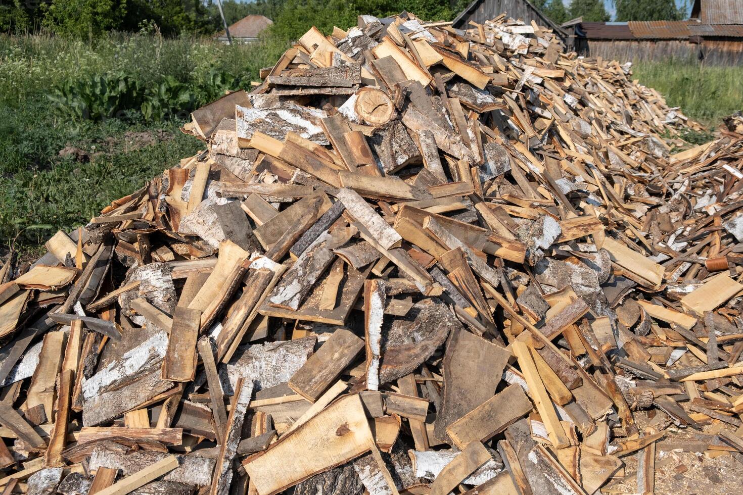 A large pile of different sawn firewood for the stove. photo