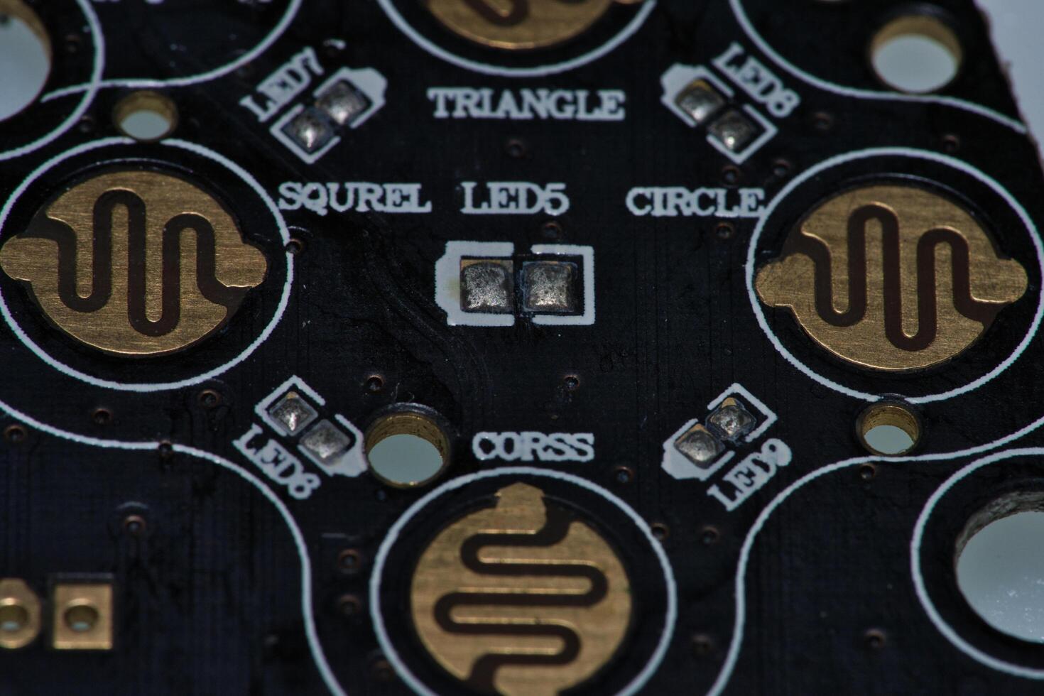a close up of a circuit board with gold and silver circles photo
