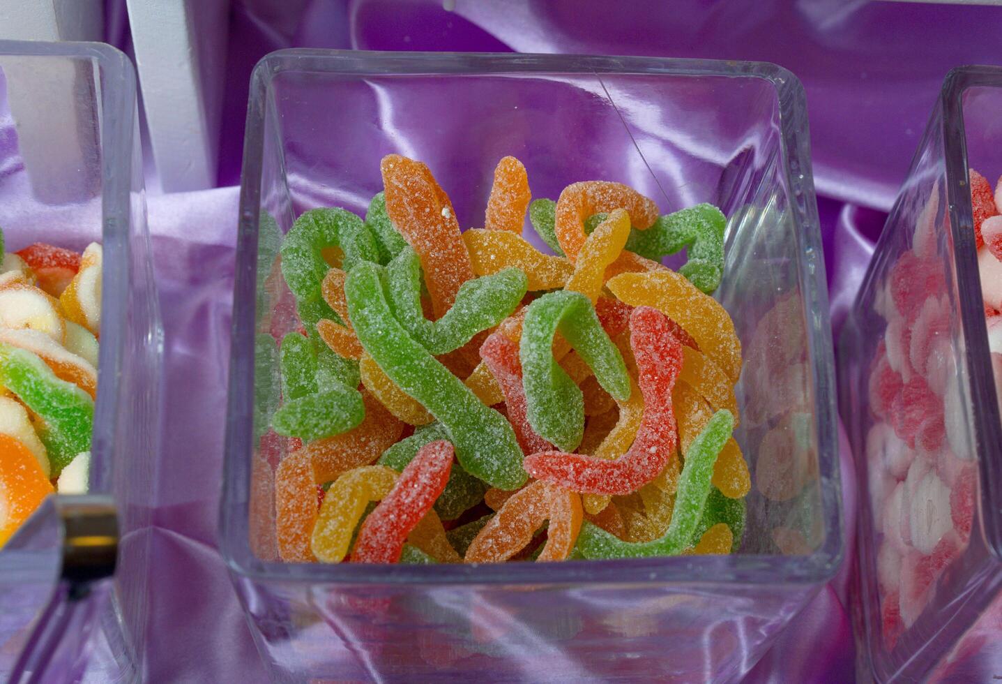 a display of different colored gummy worms photo