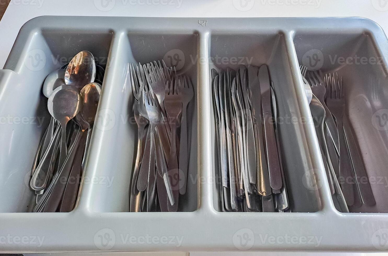 clean cutlery in a cutlery box with knives, forks, spoons in a canteen. photo