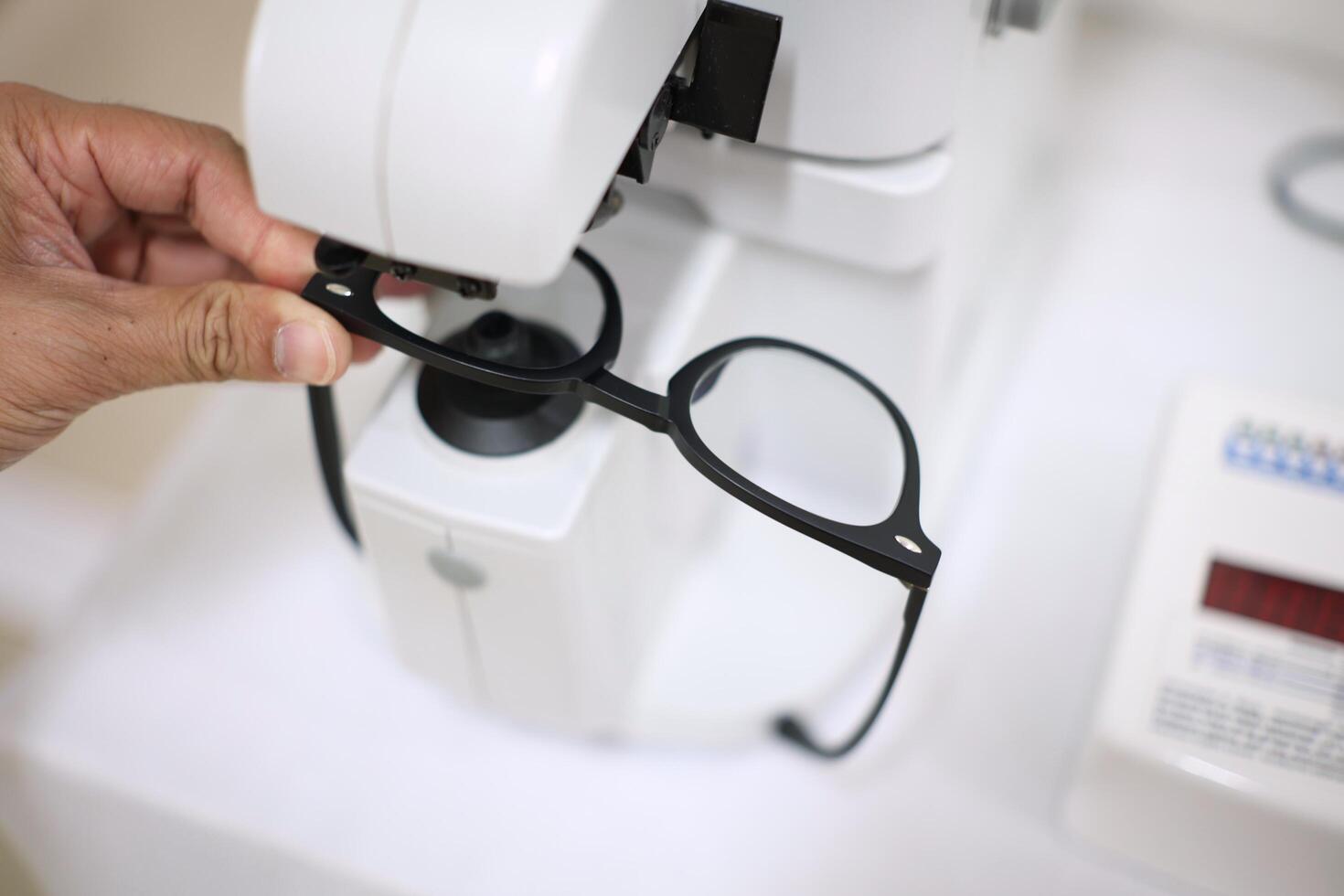 Hand holding eyeglasses in optical store photo