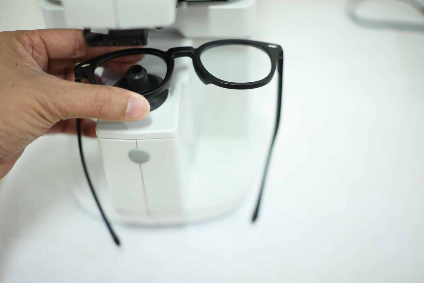 Hand holding eyeglasses in optical store photo