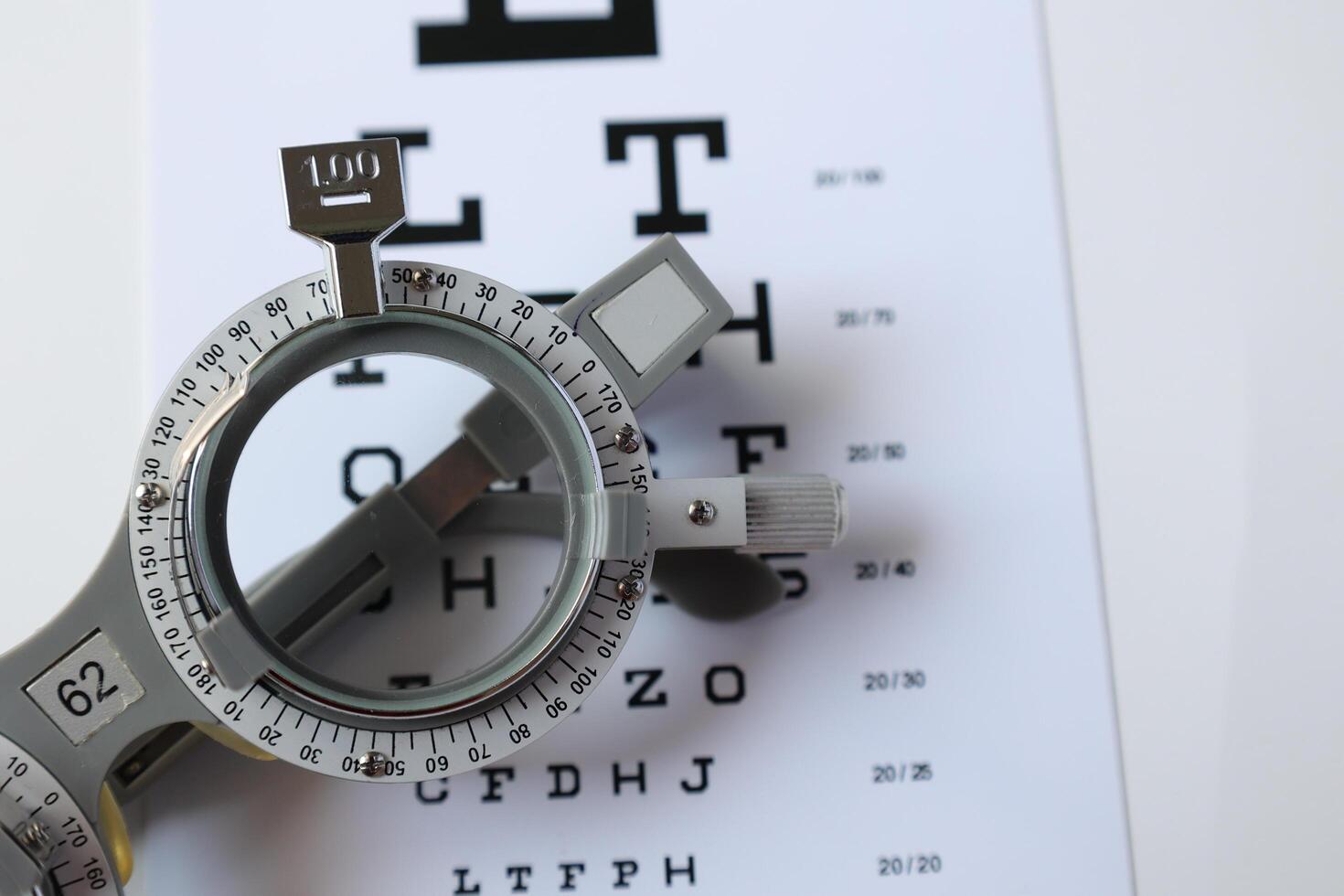 Trial frame glasses for eye test on chart in optical store photo