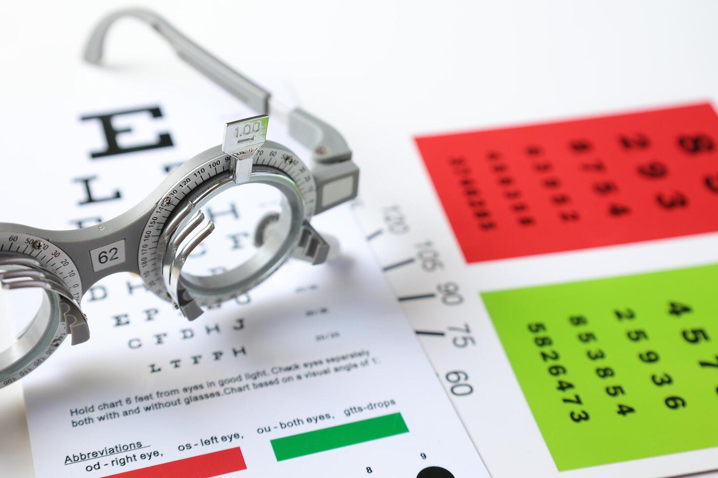 Trial frame glasses for eye test on chart in optical store photo