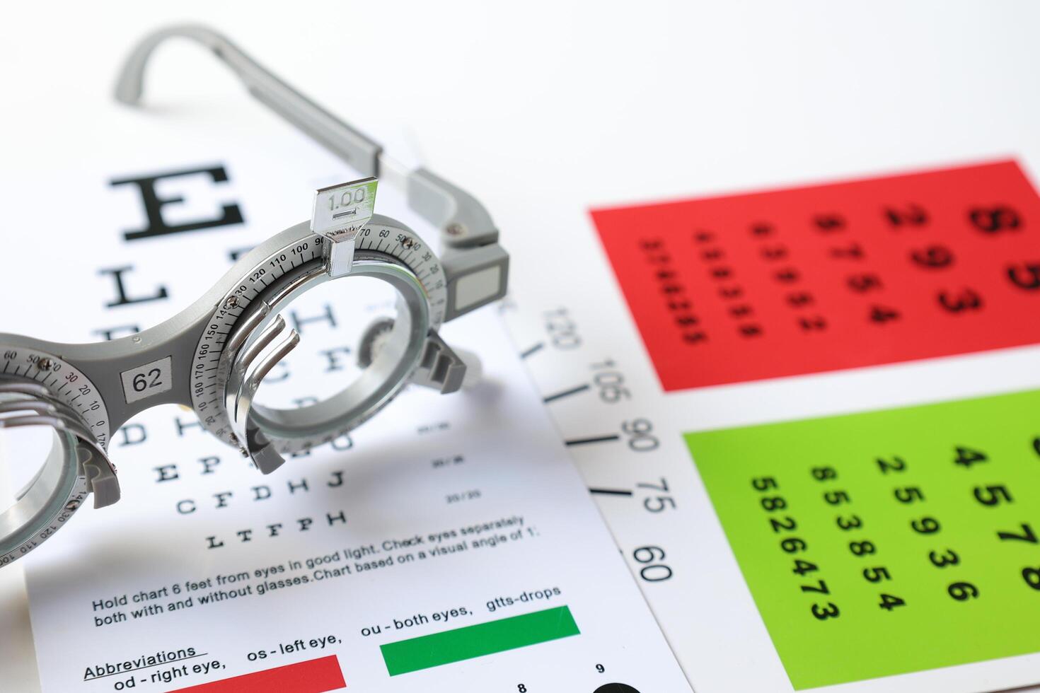 Trial frame glasses for eye test on chart in optical store photo
