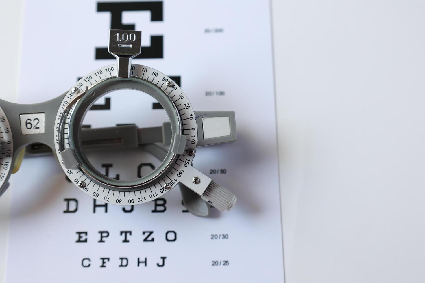 Trial frame glasses for eye test on chart in optical store photo