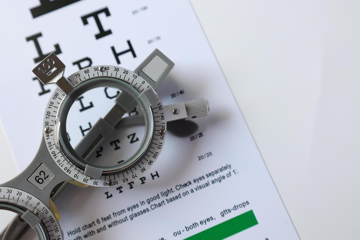 Trial frame glasses for eye test on chart in optical store photo
